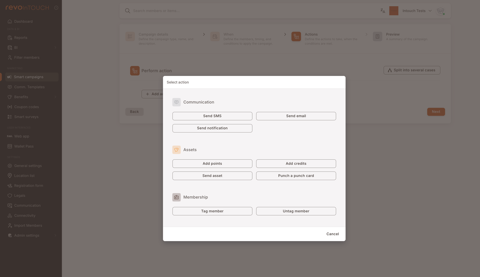 Modal del paso 3 "Seleccionar acción" con las nueve acciones agrupadas bajo Comunicación (Enviar SMS, Enviar correo, Enviar notificación), Activos (Añadir puntos, Añadir créditos, Enviar activo, Sellar una tarjeta perforada) y Membresía (Etiquetar miembro, Desetiquetar miembro)
